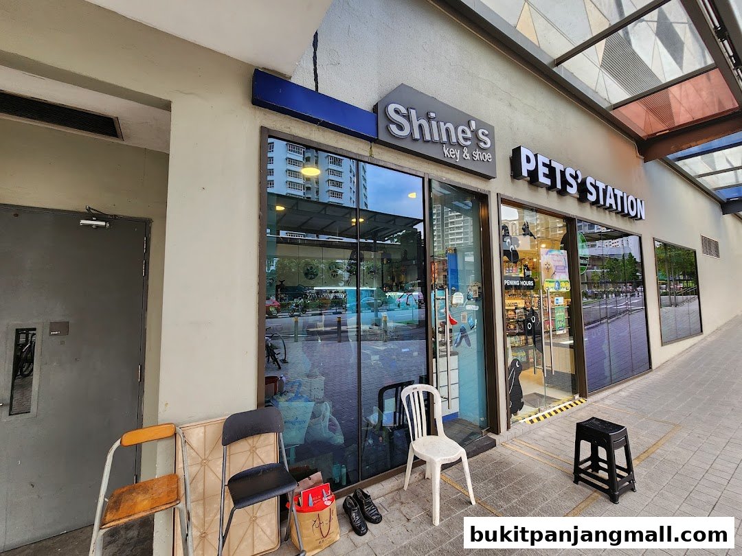 The exterior of Shine's Key and Shoe and Pets' Station shops with chairs outside.