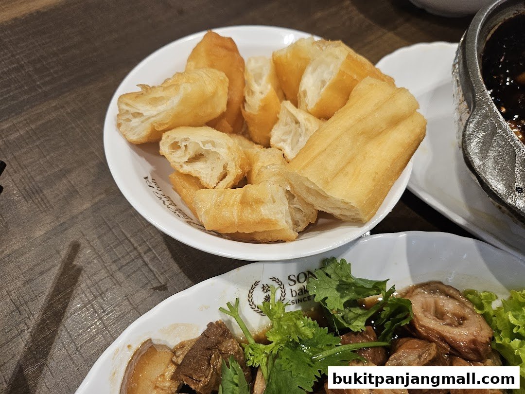 A close-up of fried dough sticks and braised pork belly served at Song Fa Bak Kut Teh.