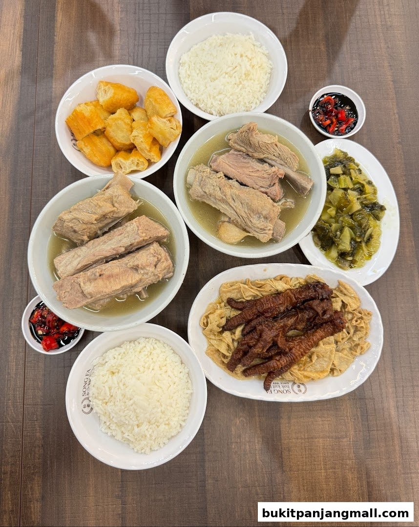 A spread of Song Fa Bak Kut Teh dishes including pork ribs, rice, fried dough, and pickled vegetables.