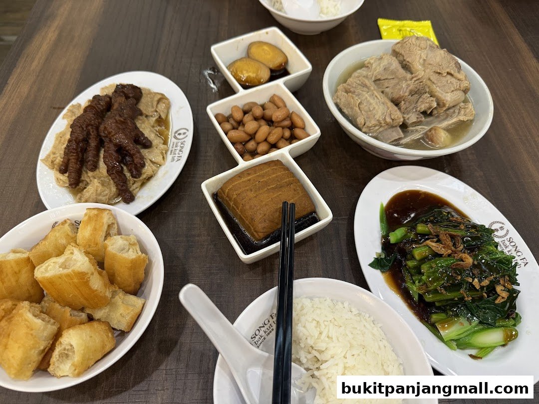 A spread of delicious Song Fa Bak Kut Teh dishes including pork ribs, braised peanuts, and fried dough sticks.