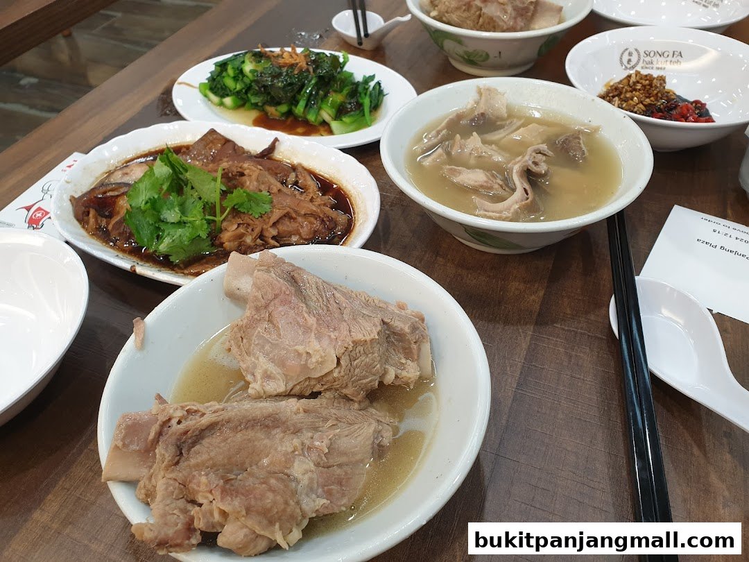 A table laden with delicious Song Fa Bak Kut Teh dishes, including pork ribs and vegetables.