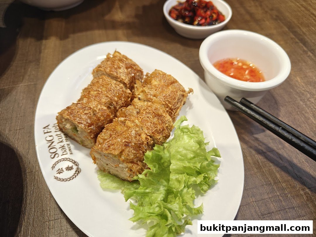 A plate of crispy fried rolls with dipping sauce and chili paste at Song Fa Bak Kut Teh.