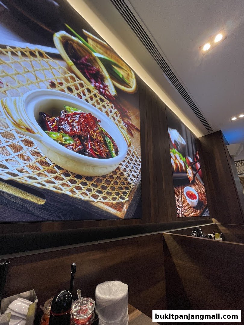 Interior shot of a restaurant with large food images on the wall and dining booths.