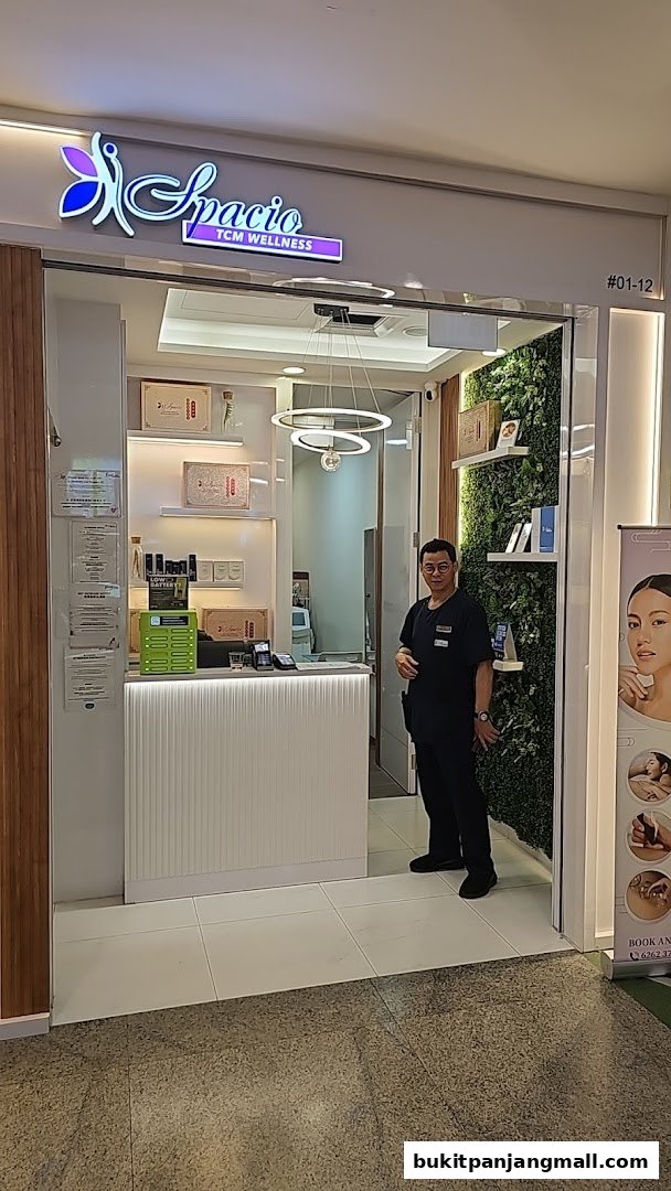 A man stands at the entrance of Spacio TCM Wellness, a modern wellness center.