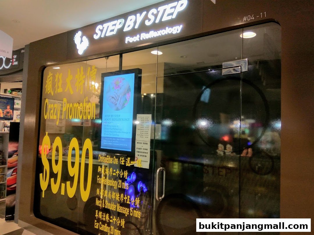 The entrance of Step by Step Foot Reflexology shop with a promotion sign.