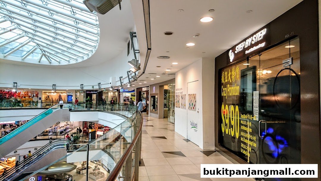 A shopping mall interior with escalators and various shop fronts, including 'Step by Step' with a promotion.