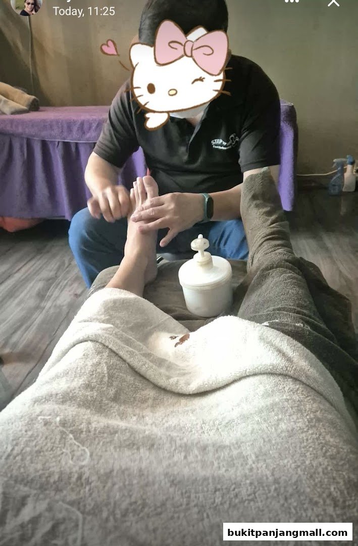 A person receives a foot massage at a spa, with a therapist's hands working on their foot.