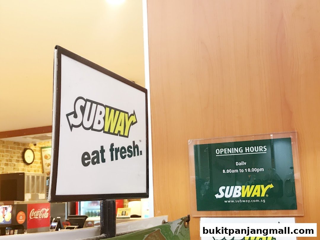 Subway shop sign with 'eat fresh' slogan and opening hours posted.