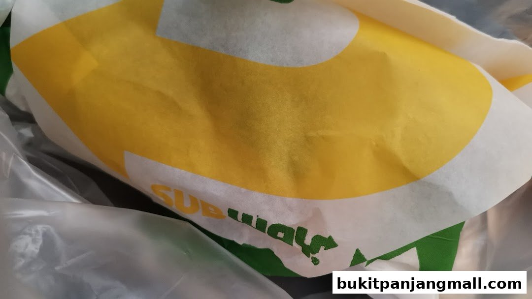 A close-up of a Subway branded paper bag with its iconic yellow and green logo.