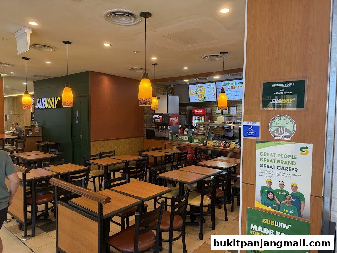 Interior view of a Subway restaurant with seating, counter, and branding.