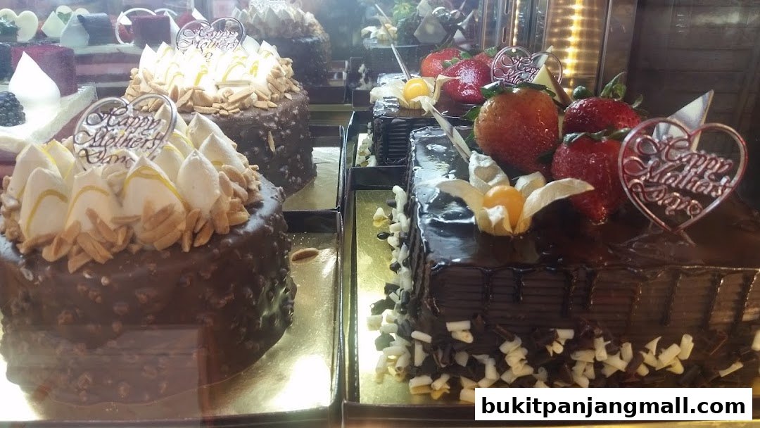 Close-up of delicious chocolate cakes decorated with fresh strawberries and 'Happy Mother's Day' toppers.