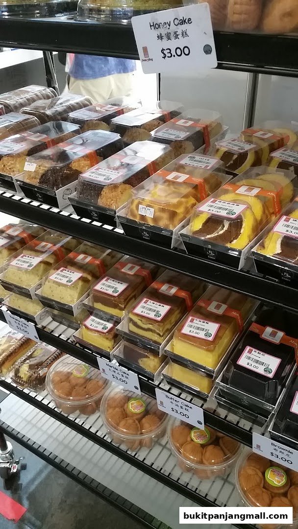 A display of various cakes and pastries in clear packaging at Swee Heng Bakery.