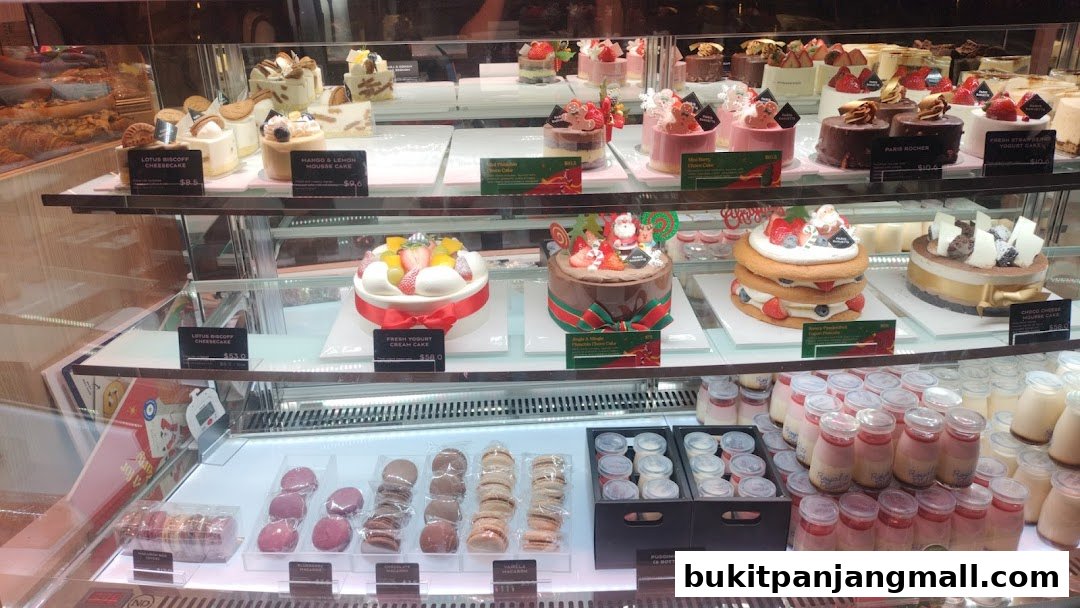 A display case filled with various cakes, pastries, and bottled desserts from Swee Heng Bakery.