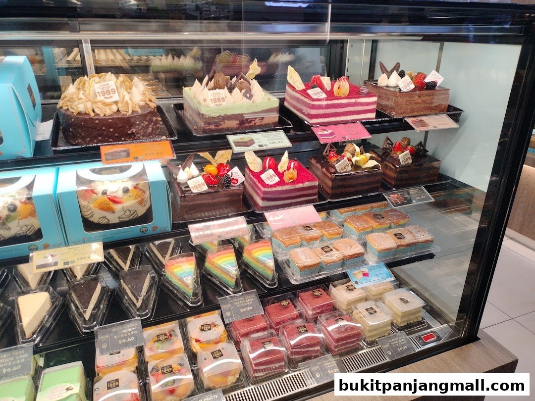 A display case filled with a variety of beautifully decorated cakes and pastries.