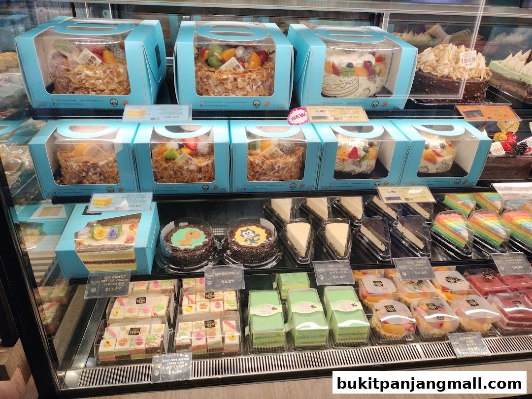 A display case filled with various cakes, pastries, and desserts from Swee Heng Bakery.
