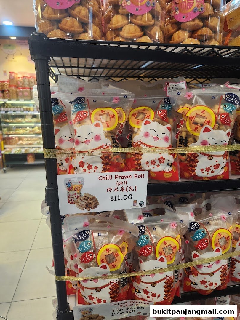A display of packaged snacks, including Chilli Prawn Rolls and Peanut Candies, at Swee Heng Bakery.