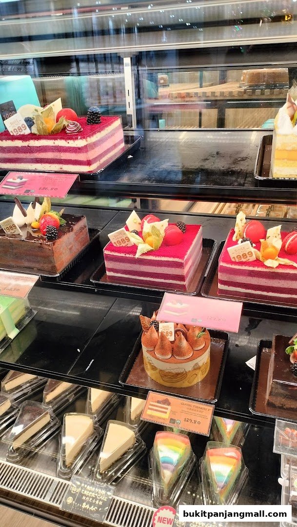 A display case filled with various beautifully decorated cakes and cake slices.