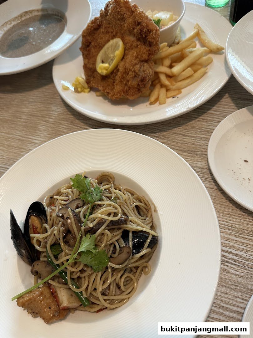 A close-up of two delicious meals: a breaded chicken cutlet with fries and a seafood pasta dish.