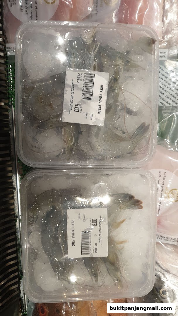 Two containers of fresh grey prawns packed in ice, with price labels visible.