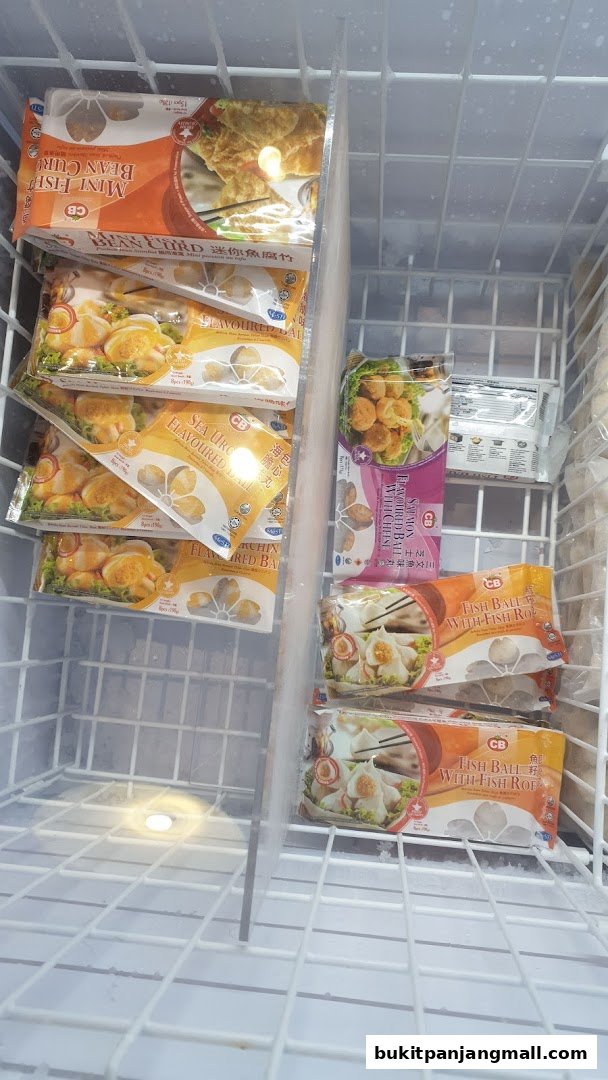 Frozen seafood products, including fish balls and bean curd, displayed in a freezer.