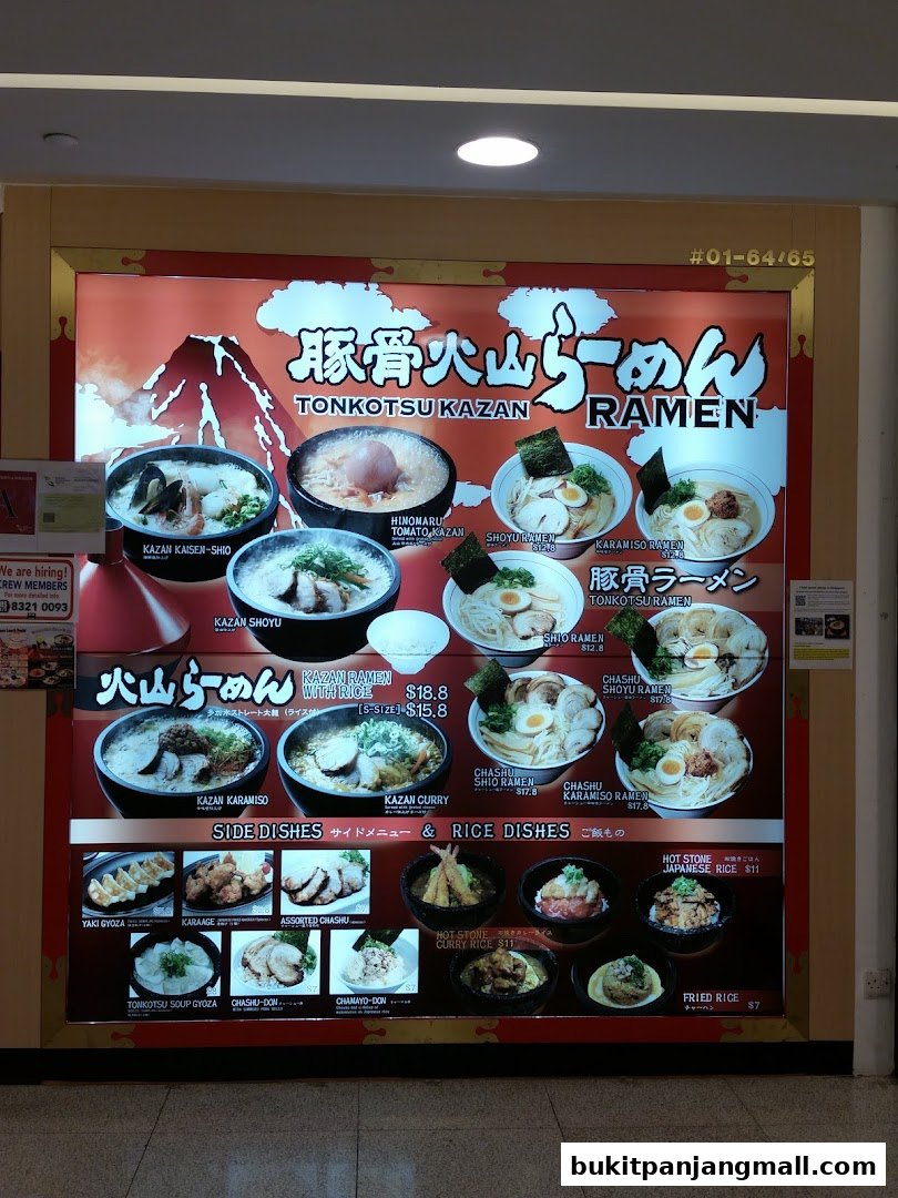 A brightly lit menu board for Tonkotsu Kazan Ramen, showcasing various ramen dishes and side orders.