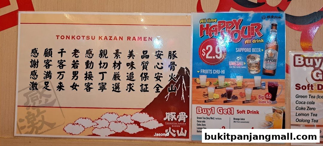 A menu board for Tonkotsu Kazan Ramen featuring happy hour drinks and soft drinks.