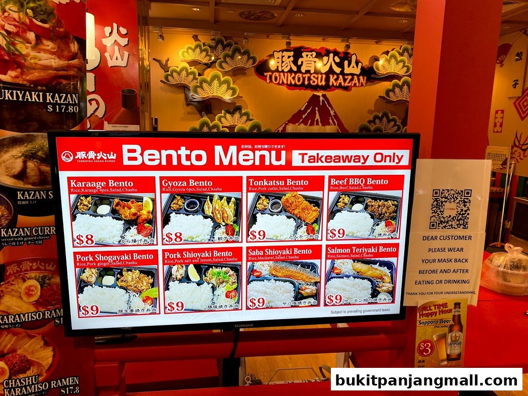 A digital menu board displays various bento boxes and their prices at Tonkotsu Kazan.