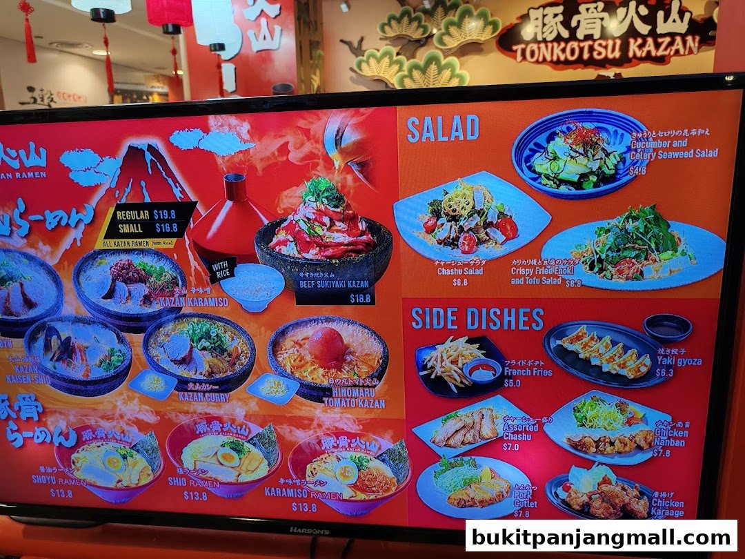A digital menu board displaying various ramen dishes, salads, and side dishes with prices.