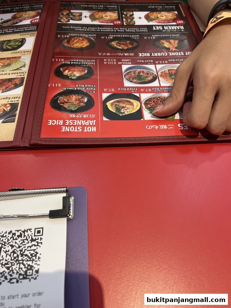 A close-up of a restaurant menu featuring various Japanese rice dishes and ramen sets.