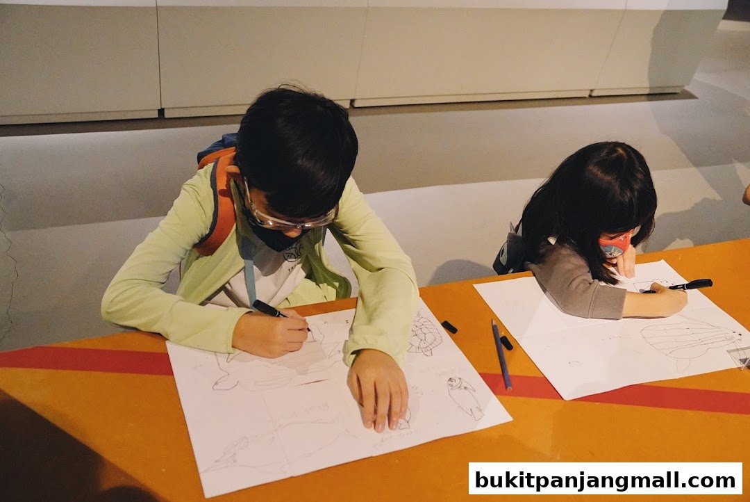 Two children are drawing animals on paper at a table.