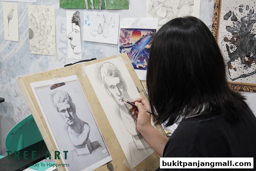 A student is drawing a bust from a reference image at an art class.