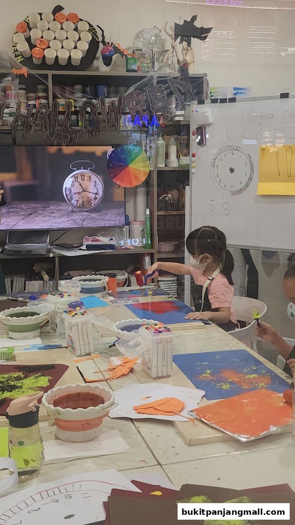 Children engaged in a creative art class, painting and crafting at tables.