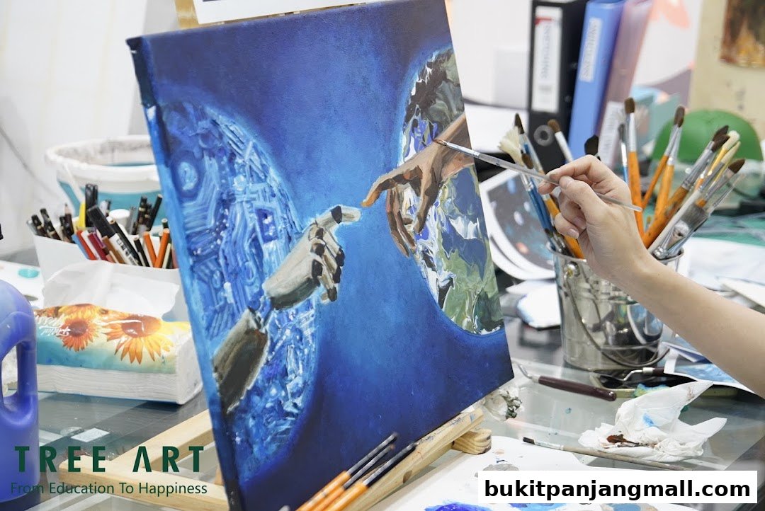 A person's hand paints a canvas depicting a robot and human hand reaching for each other.