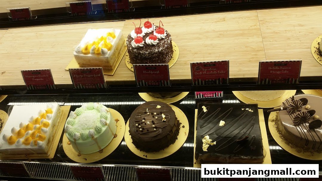 A display case filled with various beautifully decorated cakes and pastries.