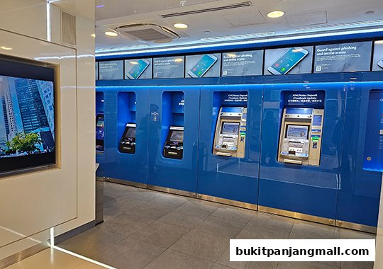 Interior view of a UOB bank branch with multiple ATMs and informational displays.