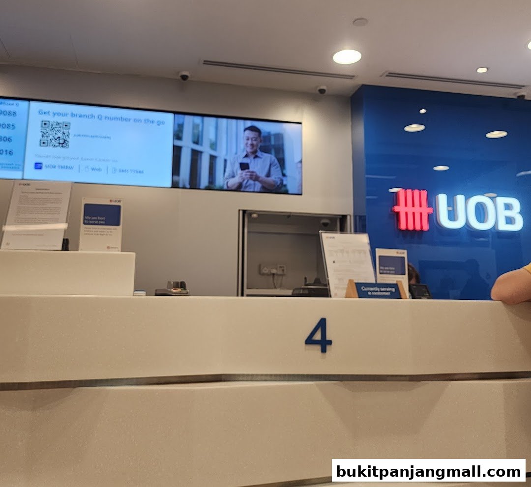 Interior of a UOB bank branch with a digital display and service counter.