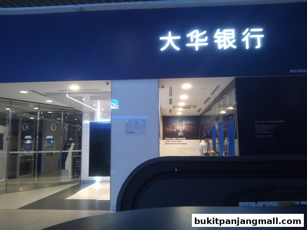 The entrance of a UOB bank branch with illuminated signage and glass doors.