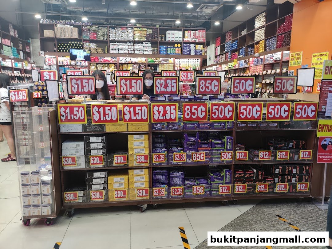 A retail store interior with shelves stocked with various products and prominent price signage.