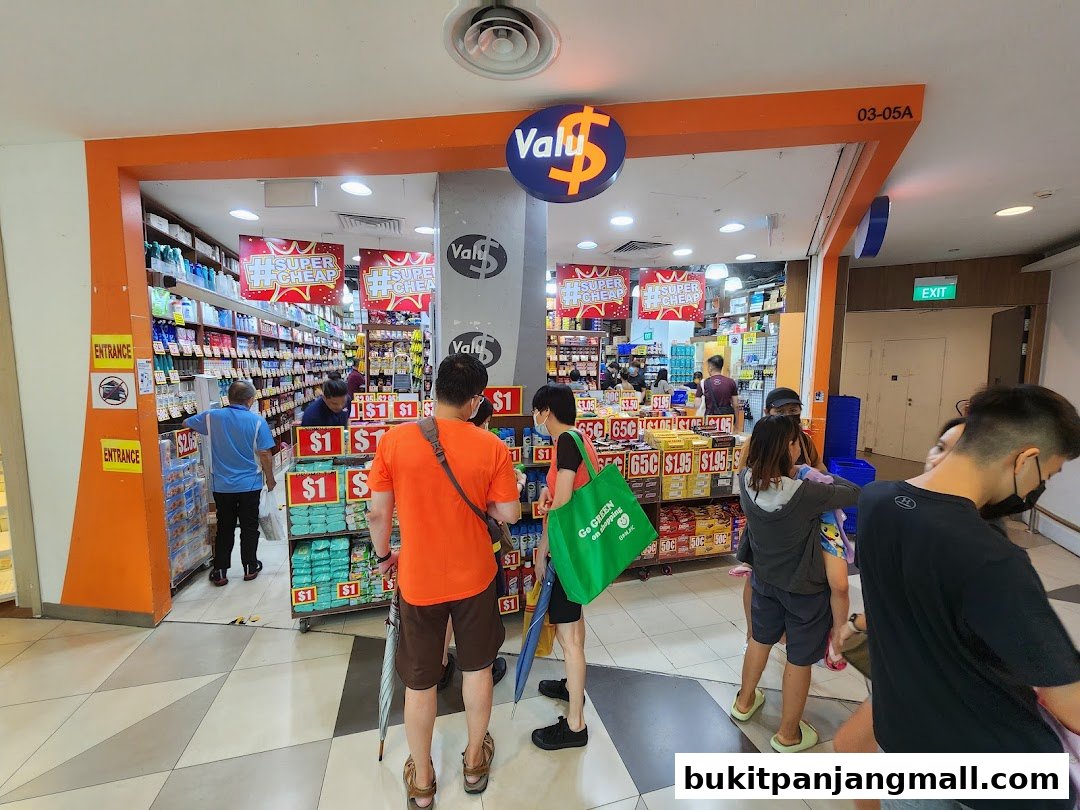People are shopping at Valu, a store with many products displayed and signs indicating low prices.
