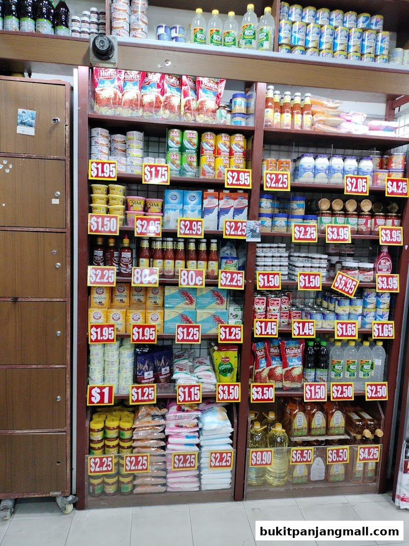 A well-stocked grocery store aisle with shelves full of various food items and prices displayed.