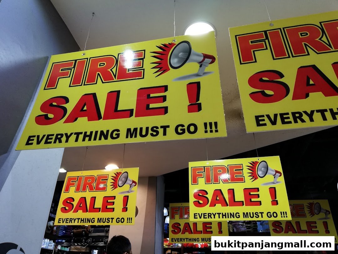 Yellow signs with red text announcing a 'Fire Sale' with 'Everything Must Go!!!'.