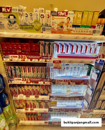 Shelves stocked with various toothpaste brands and oral care products.