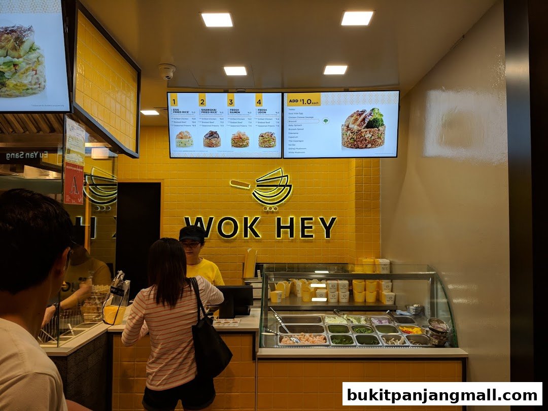 A Wok Hey counter with a digital menu displaying food options and prices.