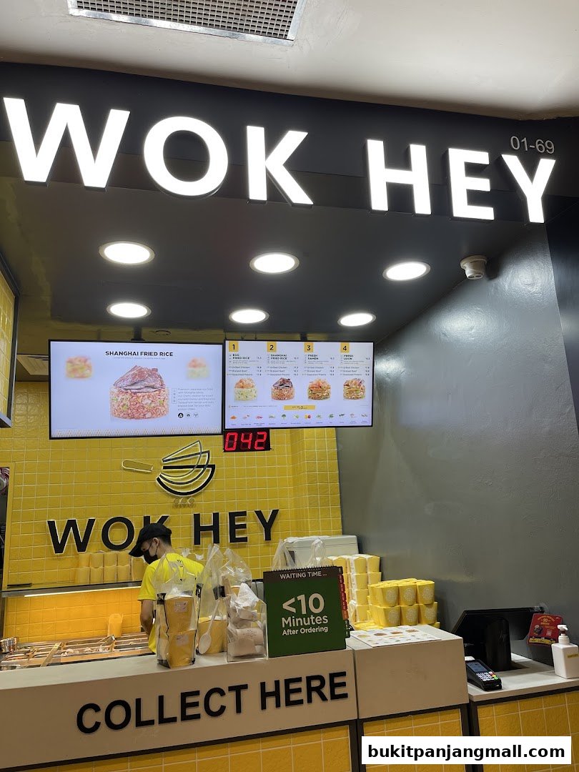 The Wok Hey shop front with a bright yellow interior and a 'Collect Here' sign.