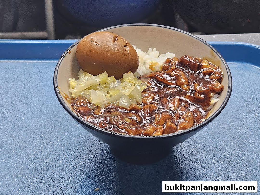 A bowl of Taiwanese braised pork rice with a braised egg and pickled cabbage.