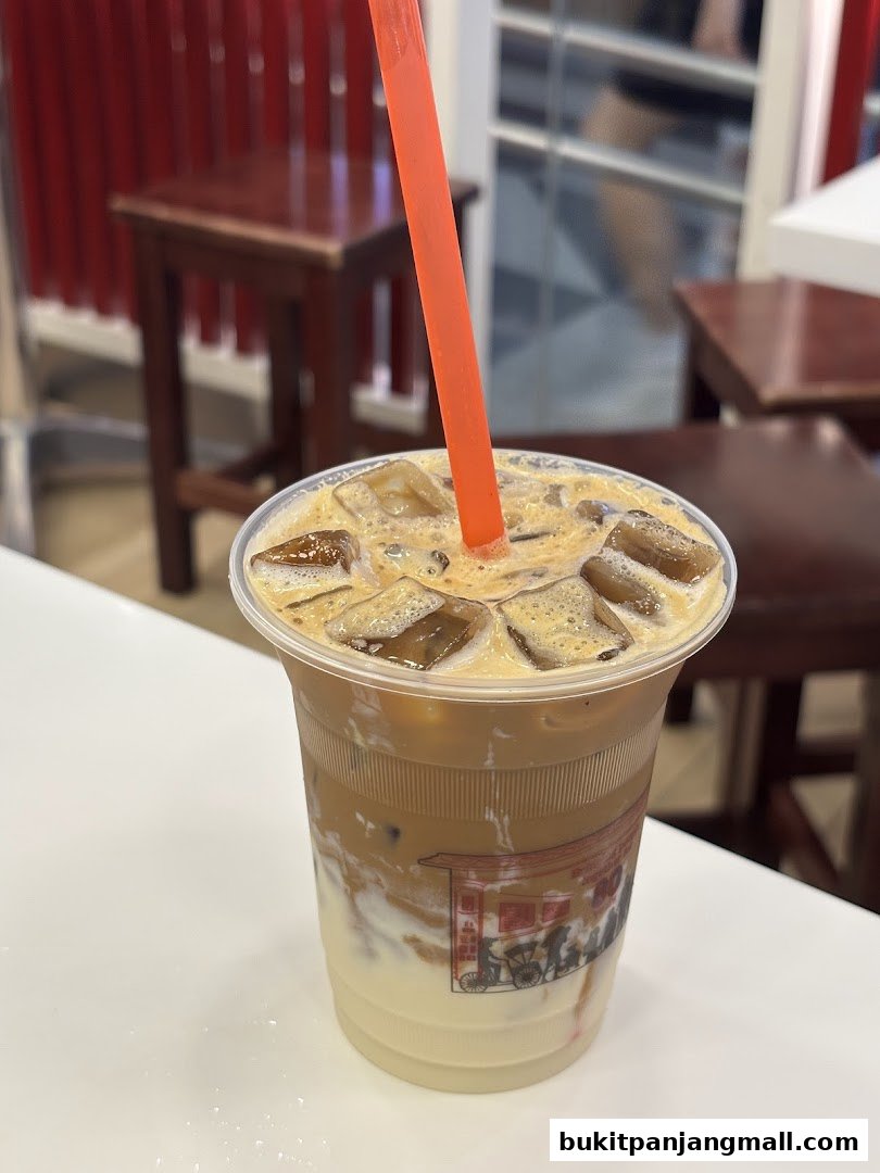 A refreshing iced coffee with milk and ice in a clear plastic cup with a straw.