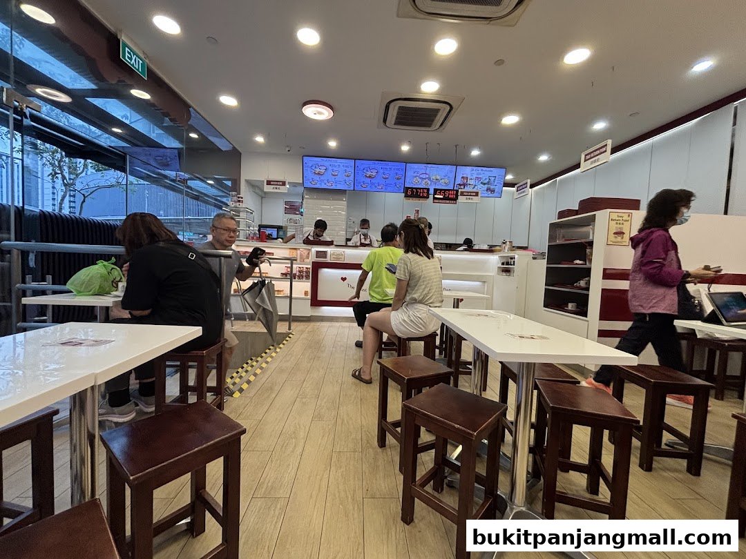 Interior view of Ya Kun Kaya Toast with customers seated at tables and staff behind the counter.