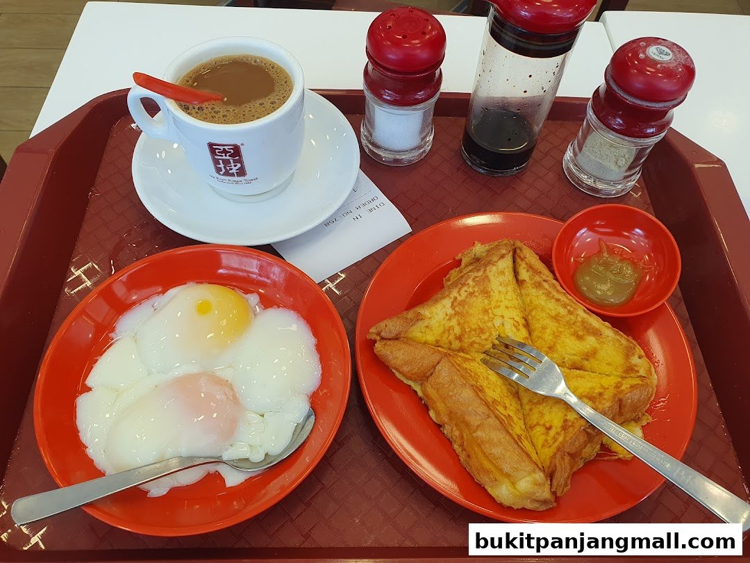 A tray of traditional Singaporean breakfast: kaya toast, soft-boiled eggs, and coffee.