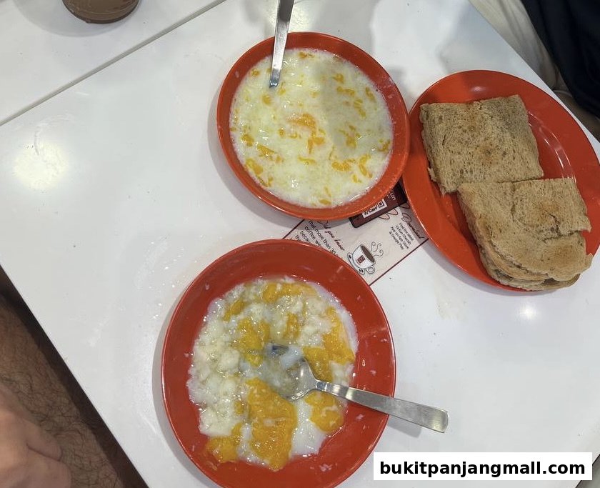 Two bowls of soft-boiled eggs with toast on a white table at Ya Kun Kaya Toast.