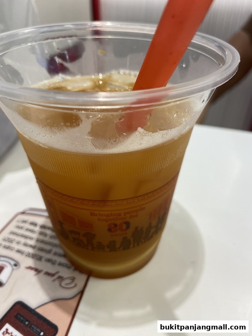 A close-up of an iced beverage in a clear plastic cup with a red straw.